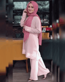 a woman wearing a pink hijab and a pink shirt