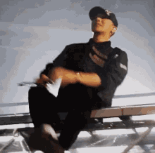 a man is sitting on a bench wearing a ny hat