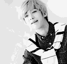 a black and white photo of a young man wearing a plaid shirt