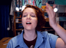 a woman with red hair is wearing a blue shirt and a red shirt with a star on it