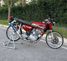 a red honda motorcycle is parked on a road
