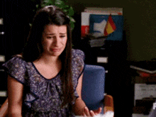 a woman in a purple shirt is crying in front of a filing cabinet