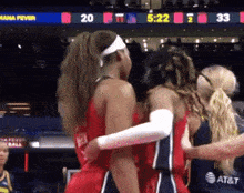 a group of female basketball players hugging each other in front of a scoreboard that says mana fever