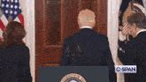 a man stands behind a podium with the president of the united states seal on it