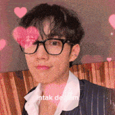 a young man wearing glasses has a heart in his eye and the words intak de sam below him