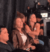 a group of people are sitting in a room laughing .