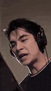 a close up of a man wearing headphones making a face