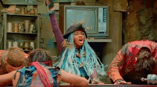 a girl with blue braids and a pirate hat is standing in front of a television