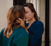 two women are touching each other 's faces in a room