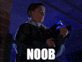 a person is holding a gun and the word noob is on the bottom