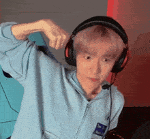 a man wearing headphones and a blue jacket with the letter h on the front