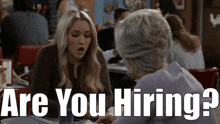 two women sitting at a table with the words " are you hiring "