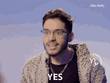 a man wearing glasses and a sweater with the word yes on it