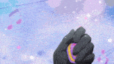 a person in a black glove is holding a heart shaped item with the number 2 on it
