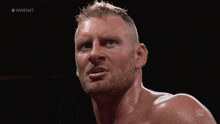a close up of a man 's face with #wwe nxt on the bottom