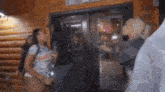 a group of people are standing in front of a glass door in a room .