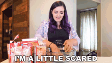 a woman with purple hair says i 'm a little scared while mixing ingredients in a bowl