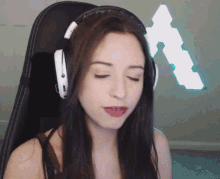 a woman wearing headphones sits in a chair