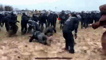 a group of police officers are fighting a group of people