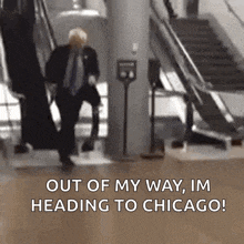 a man in a suit and tie is walking down an escalator and says out of my way im heading to chicago !