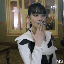 a woman with a ring on her finger and the word ms on the bottom right