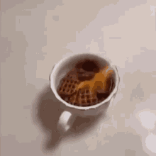 a cup filled with a variety of snacks , including waffles , nuts , and cheese .