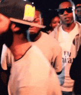 a man wearing a fly emirates t-shirt is dancing in a crowd .