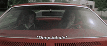 two people in a red car with the words deep inhale written on the hood
