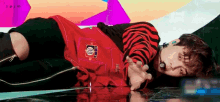 a young man is laying on the floor on a stage .