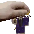a person is holding a toy gun in their hand and it looks like a minecraft character .