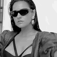 a black and white photo of a woman wearing sunglasses .