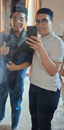 a man taking a selfie with another man in front of a mirror