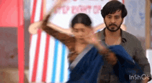 a man is holding a woman in his arms while they are dancing in a room .