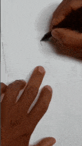 a person is drawing a heart with a pen