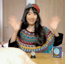 a woman sitting at a table with a crystal ball and a box that says magic crystal ball