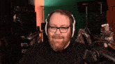 a man with a beard wearing headphones is smiling