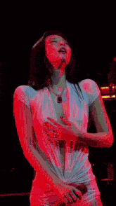 a woman in a very revealing white dress is dancing on a stage