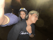 a man wearing a black shirt that says enthusiast poses with a woman wearing a helmet