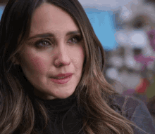 a close up of a woman 's face with a black turtleneck