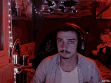 a man wearing headphones in front of a sign that says say nothing