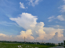 a blue sky with white clouds over a field