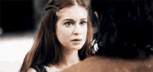a woman with long brown hair is looking at a man with black hair .