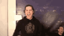 a man wearing a black sweatshirt with the letter k on it