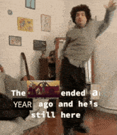 a man is dancing in a room with the words " the year ago and he 's still here " below him