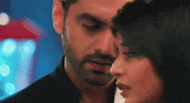 a close up of a man and woman looking at each other