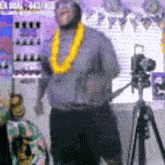a man is standing in front of a camera on a tripod .