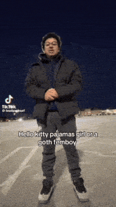 a man standing in a parking lot with a caption that says ' hello kitty pajamas girl or a goth femboy '