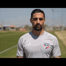a man with a beard is wearing an adidas shirt that says fc dallas on it