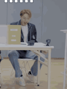 a person is sitting at a desk with their arm up