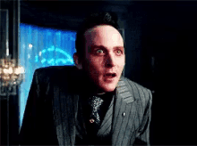 a man in a suit and tie making a surprised face
